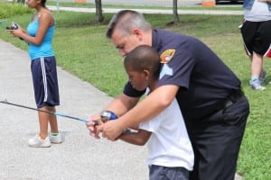 Sgt. Tim Higgins of the CPD Bureau of Community Policing assisting a student fisherman at the "Cops & Kids" Fishing Day.