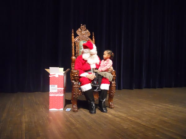 Santa listens while little Tyra Williams explains what she wants for Christmas.