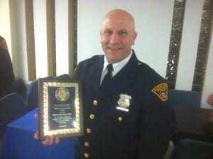 Detective Michael Kitchen #1316 holding his Community Service Award