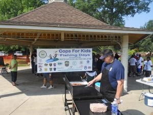 Officer Tim Riley preparing lunch for the kids after a hard day of fishing.