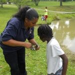 Officer Anna Mercada removes the hook from a fish caught that will be returned to the water.