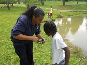 Officer Anna Mercada removes the hook from a fish caught that will be returned to the water.