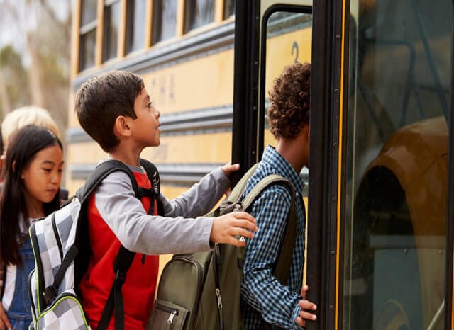 children getting on bus