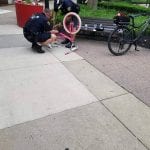 Shaker Square officer helping child with bike repair