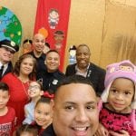 Officers pose with children in a school setting.