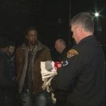 An officer holds several packs of socks.