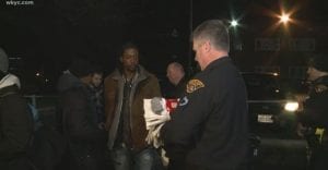 An officer holds several packs of socks.