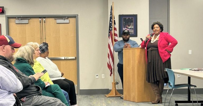 Councilwoman Howse-Jones speaks at the podium alongside a fellow city representative.