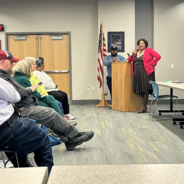 Councilwoman Howse-Jones speaks at the podium alongside a fellow city representative.