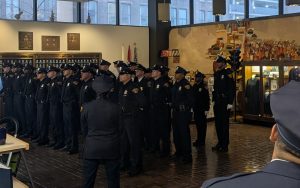 The 156th Academy Class stands at attention during their badge pinning ceremony inside the Police Museum’s main hall.