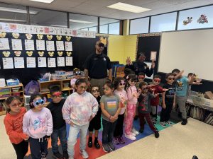 Officers Lavender and Melendez pose with a classroom of students wearing playful sunglasses during a visit to Scranton Elementary.