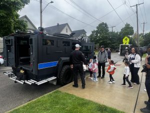 Children line up with parents and officers to explore a Cleveland SWAT vehicle outside Waverly Elementary.