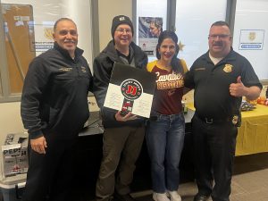 District 2 officers and staff pose together during Dispatcher Appreciation Week, holding a box of Jimmy John's as part of a lunch delivery celebration.