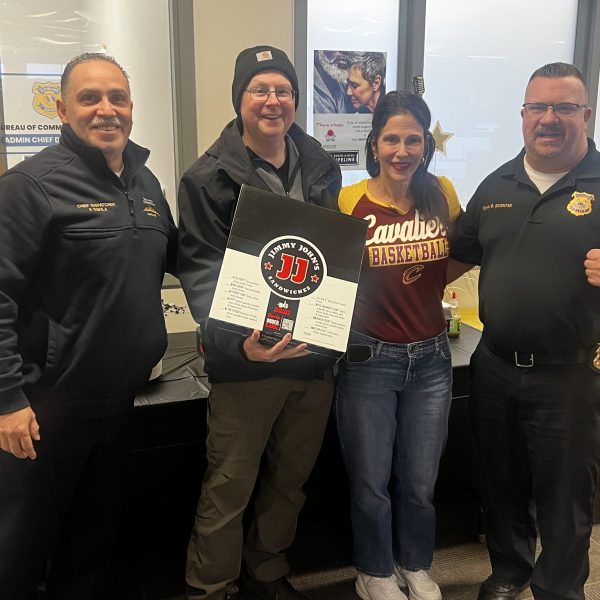 District 2 officers and staff pose together during Dispatcher Appreciation Week, holding a box of Jimmy John's as part of a lunch delivery celebration.