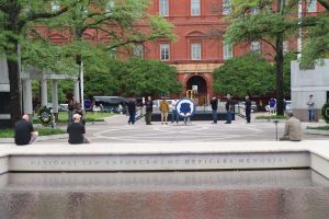 Visitors sit and reflect at the edge of the National Law Enforcement Officers Memorial fountain