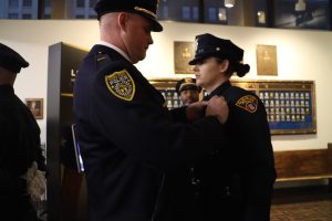 Lieutenant Rutherford of the Youngstown Police Department pins the badge on his daughter, Patrol Officer Kayla Rutherford, during her graduation from CPD Academy Class 153.