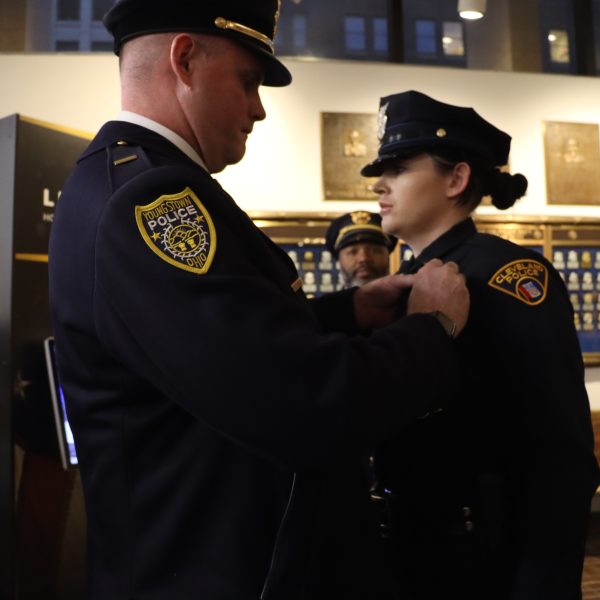 Lieutenant Rutherford of the Youngstown Police Department pins the badge on his daughter, Patrol Officer Kayla Rutherford, during her graduation from CPD Academy Class 153.