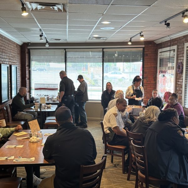 Wide view of My Friends Restaurant during Coffee with a Cop event, with community members and officers gathered at multiple tables