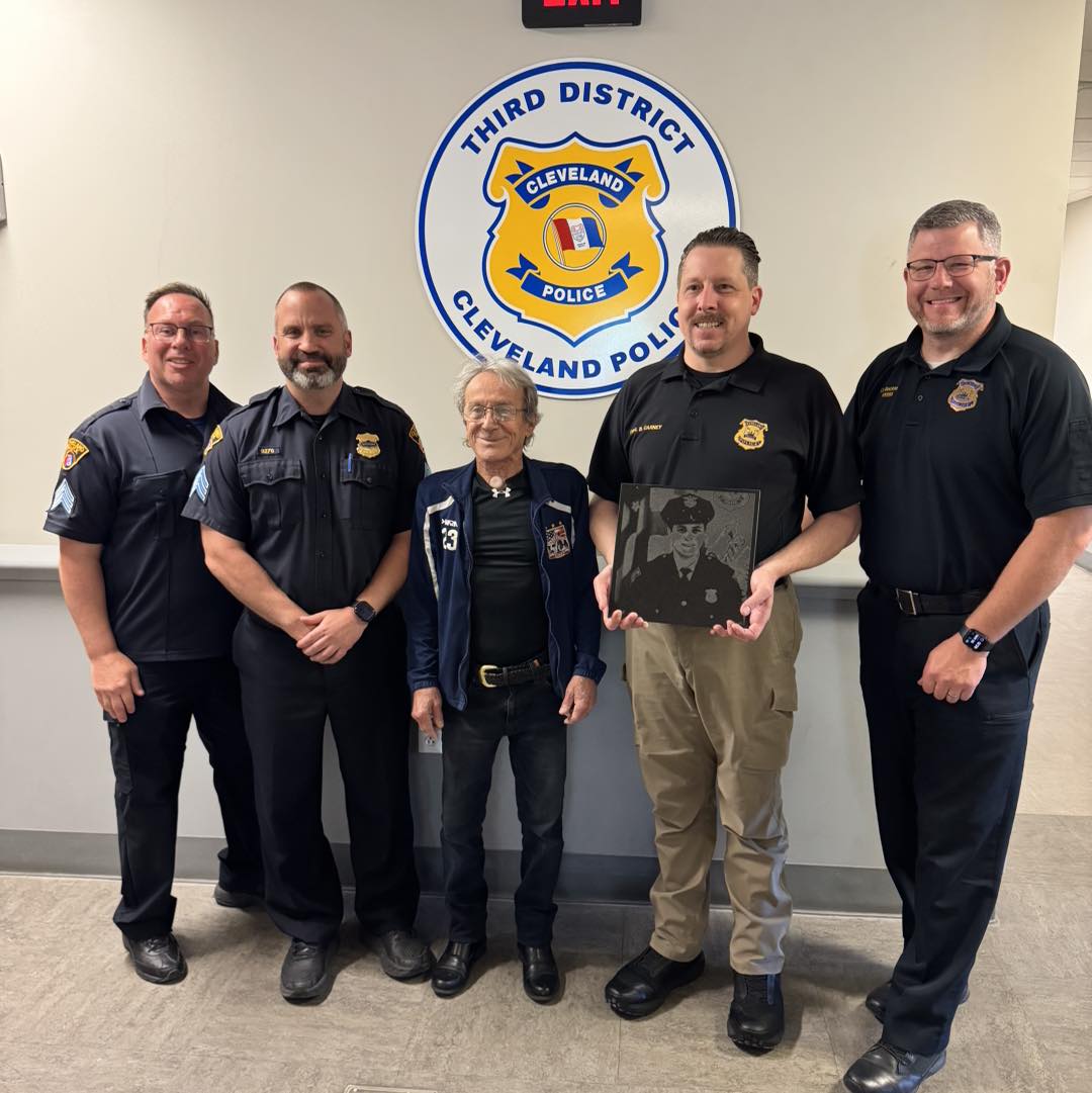 Artist Danilo Zammattio presents District 3 officers with a granite engraving of fallen Officer Jamieson Ritter inside the 3rd District lobby.