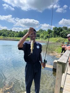 A boy shows off his catch while fishing from the dock at the Cops for Kids event.