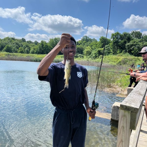 A boy shows off his catch while fishing from the dock at the Cops for Kids event.