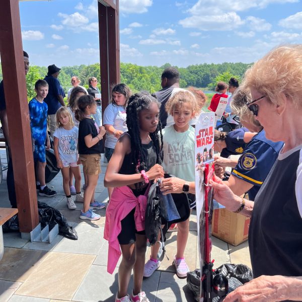 Kids line up to receive fishing rods and backpacks as giveaways during the event.