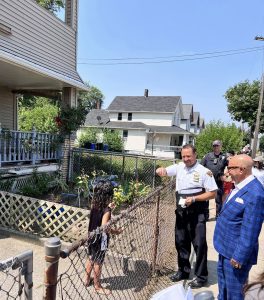 Commander Maffo-Judd greets a young girl at a neighborhood fence