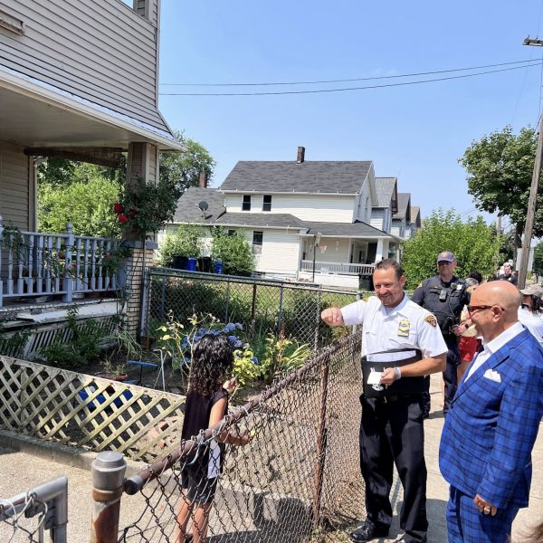 Commander Maffo-Judd greets a young girl at a neighborhood fence