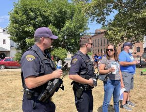Officers and Councilwoman Santana talk during a stop at a neighborhood park
