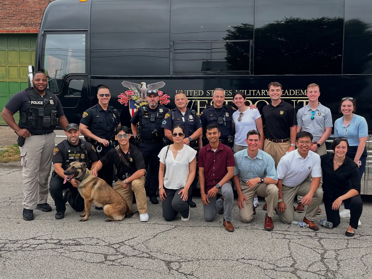 Cleveland police officers and West Point cadets pose together in front of a U.S. Military Academy bus during a visit to the Third District