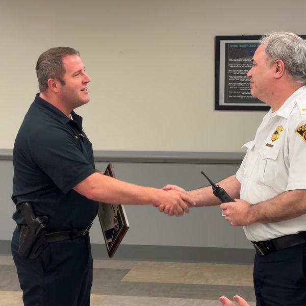 Lt. Sanders shaking hands and accepting a plaque during his retirement recognition