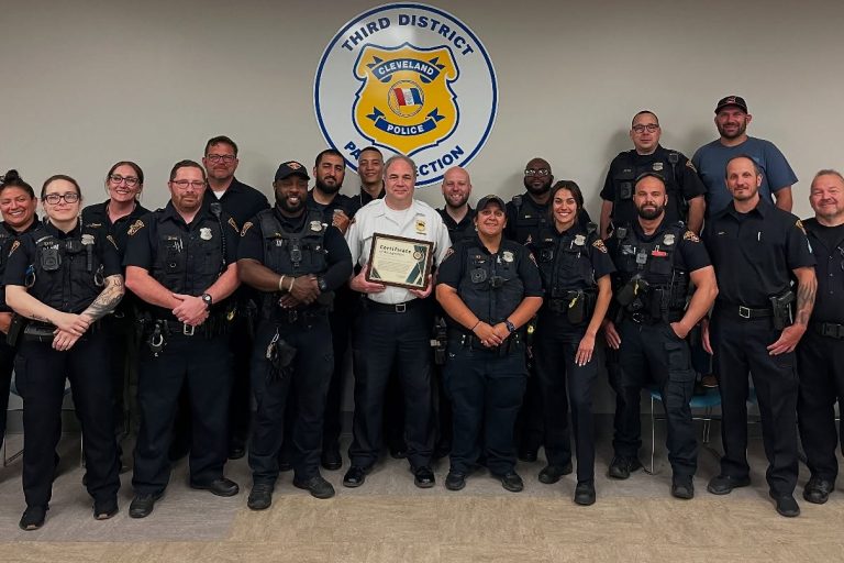 Group photo of Third District officers with Lt. Sanders holding his certificate