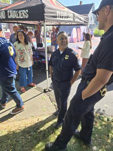 An officer speaks casually with another attendee near a Cleveland Cavaliers tent as guests mingle around the basketball court.