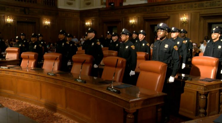 Members of the 158th Cleveland Police Academy Class standing in formation inside Cleveland City Council Chambers during their graduation ceremony.