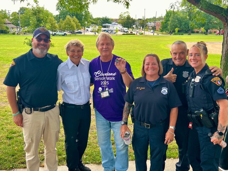 First District officers and Councilman Kelley stand together under a park tree at Halloran Park, smiling after the morning walk.