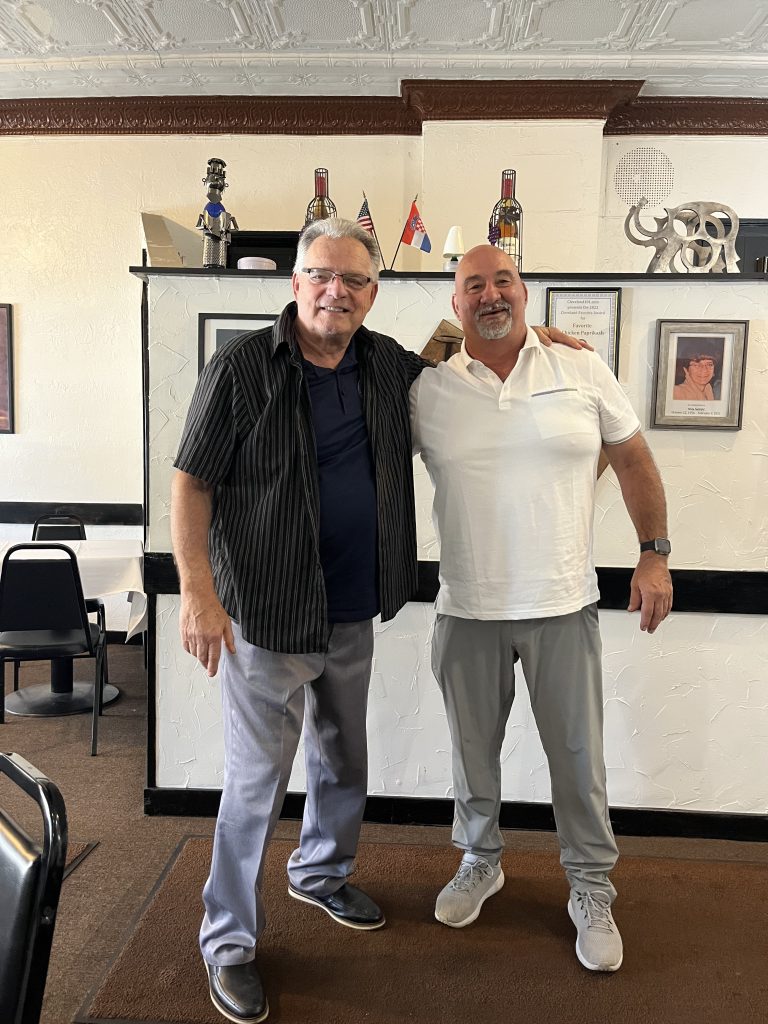 Bob Guttu and CPD Mounted Officer George Januczak standing together inside a restaurant.