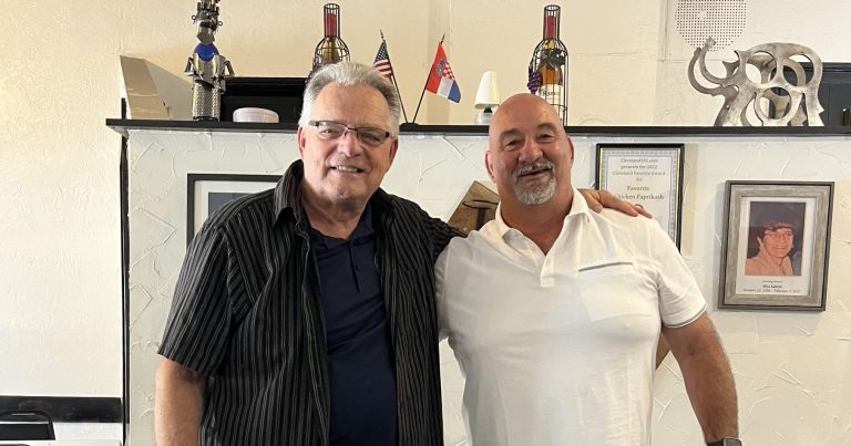 Bob Guttu and CPD Mounted Officer George Januczak standing together inside a restaurant.