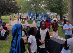 Families and children watch a group of dancers perform in traditional dress near the playground at Fairfax Recreation Center during National Night Out.