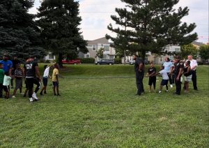 Kids, officers, and community members share the rope in a spirited tug of war game on the lawn at Fairfax Recreation Center.