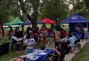 Community members gather around tables and tents set up by the Cleveland Community Relations Board and local organizations during National Night Out at Fairfax Recreation Center.