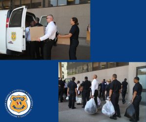 Police academy recruits load boxes and bags of donated items into a Cleveland Police van outside headquarters.