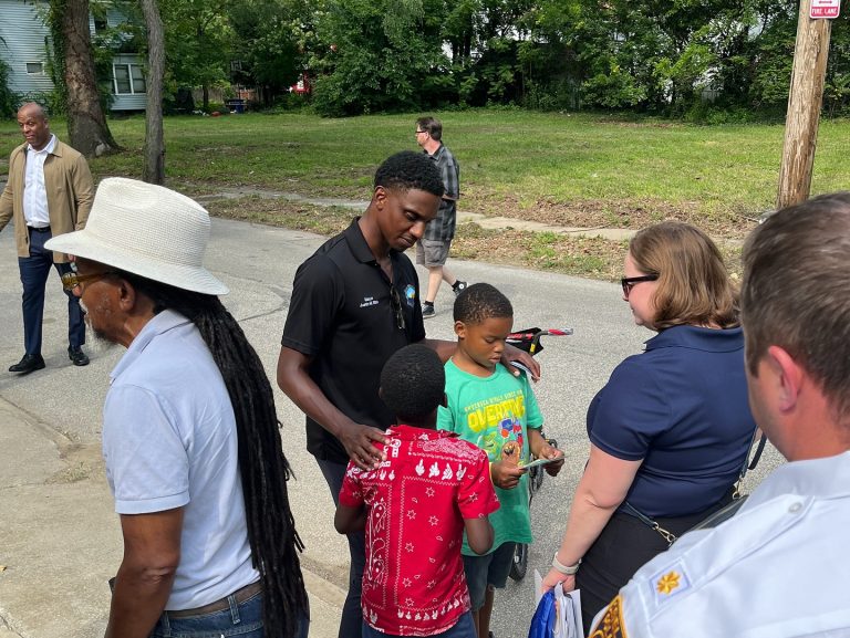 Mayor Justin Bibb stands with residents, children, and Cleveland Police officers on a residential street during the Third District safety walk.