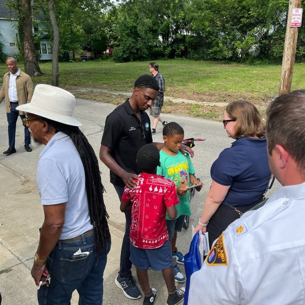 Mayor Justin Bibb stands with residents, children, and Cleveland Police officers on a residential street during the Third District safety walk.