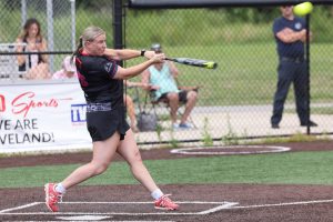 Female Cleveland Police softball player swings at a pitch during the Police/Fire softball game.