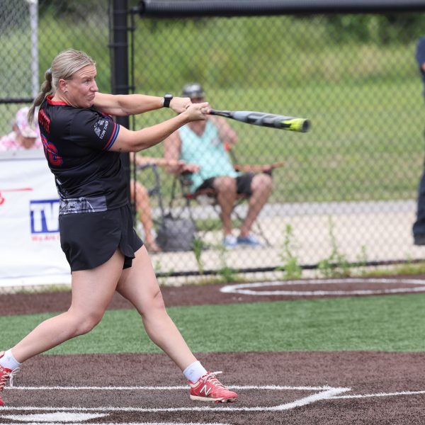 Female Cleveland Police softball player swings at a pitch during the Police/Fire softball game.
