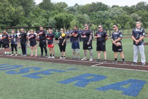 Cleveland Police softball team members stand with hands over hearts during the national anthem before the Police/Fire game.