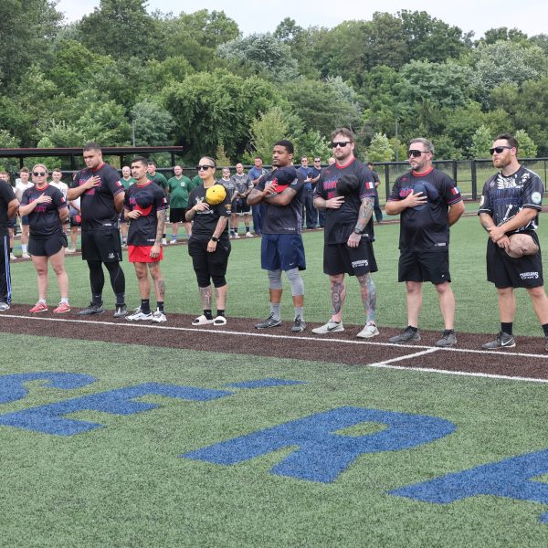 Cleveland Police softball team members stand with hands over hearts during the national anthem before the Police/Fire game.