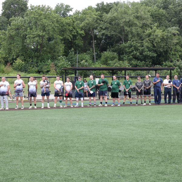 Cleveland Fire softball team members stand with hands over hearts during the national anthem before the Police/Fire game.