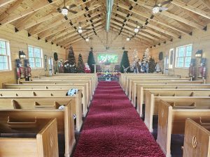 Inside the chapel at Santa’s Hideaway Hollow, decorated with Christmas trees and nativity figures at the front.