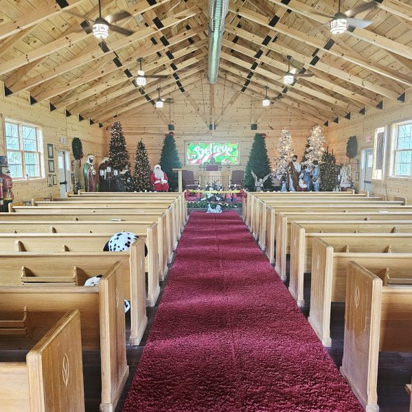 Inside the chapel at Santa’s Hideaway Hollow, decorated with Christmas trees and nativity figures at the front.